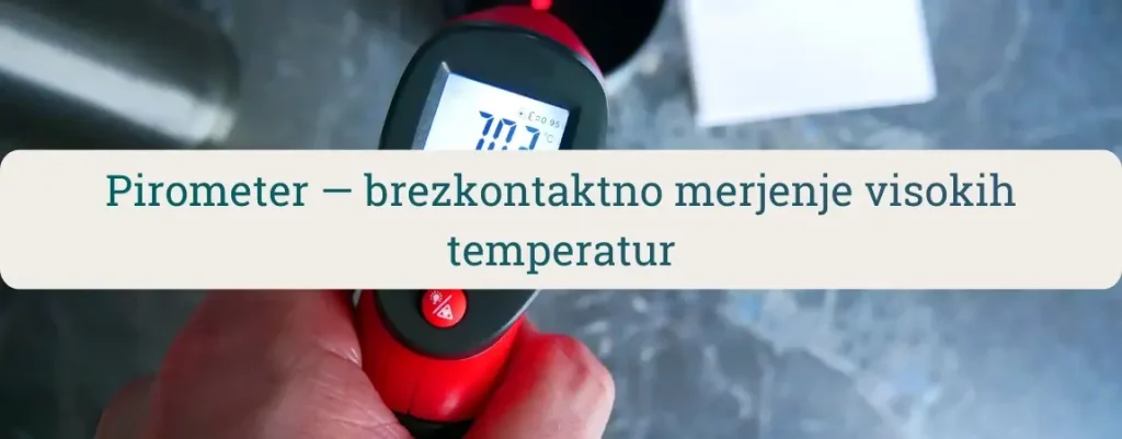 Roka drži rdeč pirometer (IR termometer) in brezkontaktno meri temperaturo površine na delovni mizi.